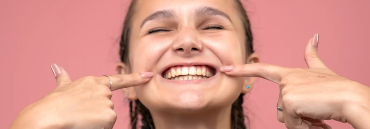 Collage dentaire, vue rapprochée jeune fille souriante rose