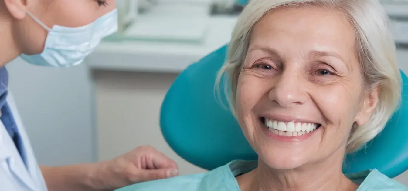 Vieille patiente blonde souriante après une intervention dentaire, Dentisterie gériatrique du Dr Parisescu