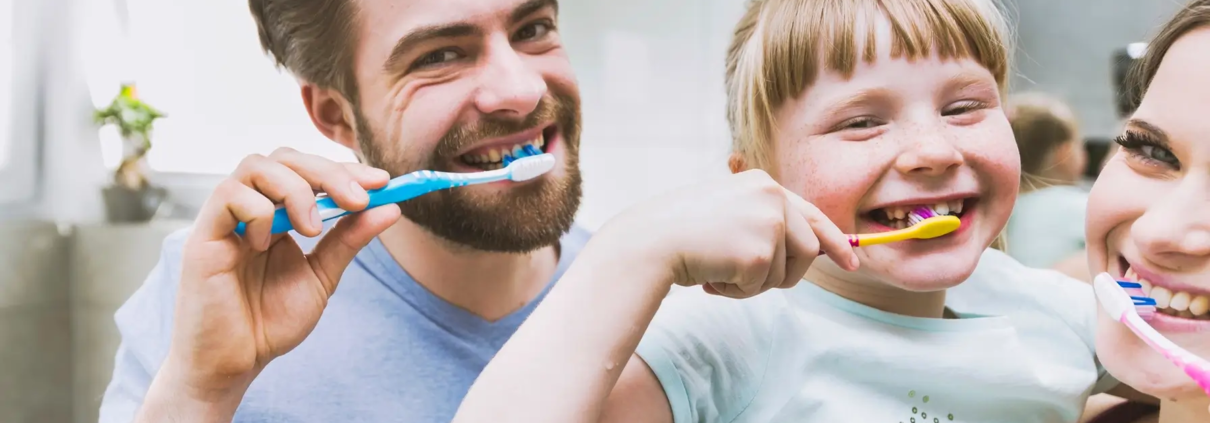 Fille et parents se brossant les dents. Ils ont appris du Dr Parisescu Utilisation-du-Fluorure