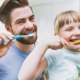 Fille et parents se brossant les dents. Ils ont appris du Dr Parisescu Utilisation-du-Fluorure