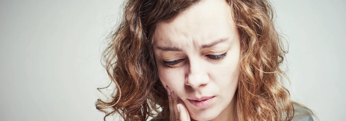 Gestion de la sensibilité dentaire après un remplissage dans le cabinet du Dr Parisescu. Femme souffrant de maux de dents. Sensibilité dentaire de concept de douleur dentaire