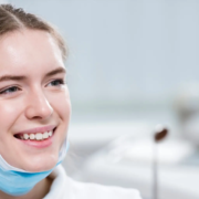 Une belle jeune femme souriante tient des outils dentaires dans ses mains, symbolisant l'importance de l'hygiène buccale.