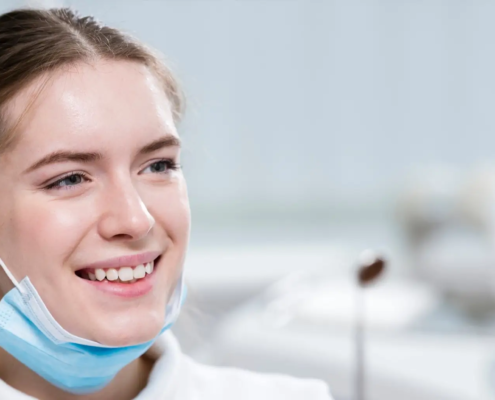 Une belle jeune femme souriante tient des outils dentaires dans ses mains, symbolisant l'importance de l'hygiène buccale.