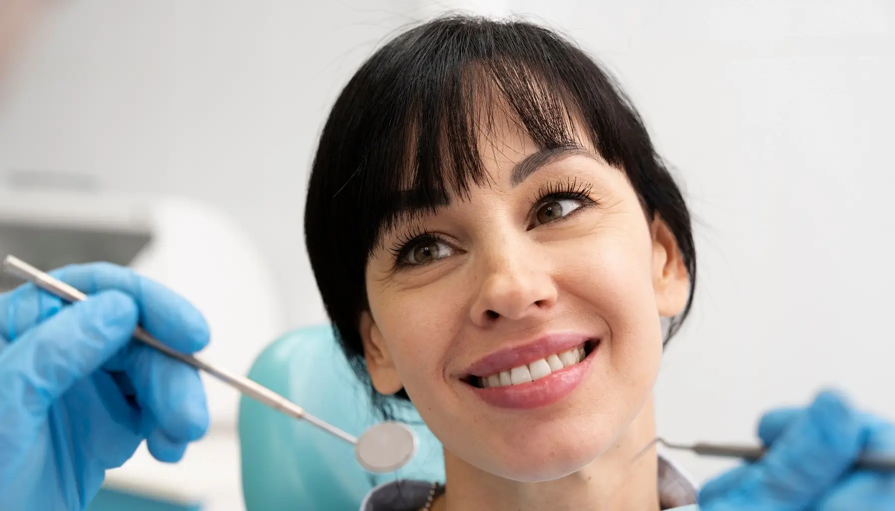 Une jeune femme assise dans un fauteuil dentaire d'un centre spécialisé dans l'hygiène et la santé bucco-dentaire.