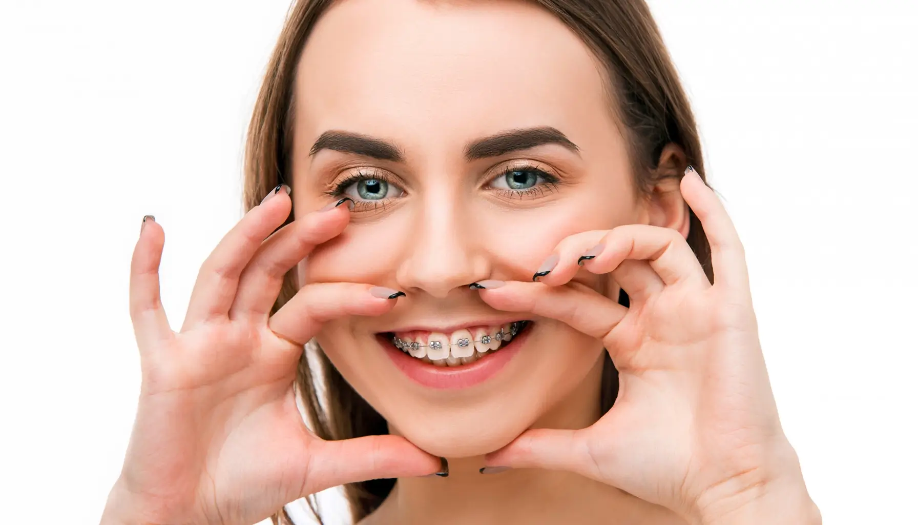 Jeune femme rayonnante avec des appareils orthodontiques, démontrant que le bien-être bucal et une bonne hygiène dentaire contribuent à la confiance en soi