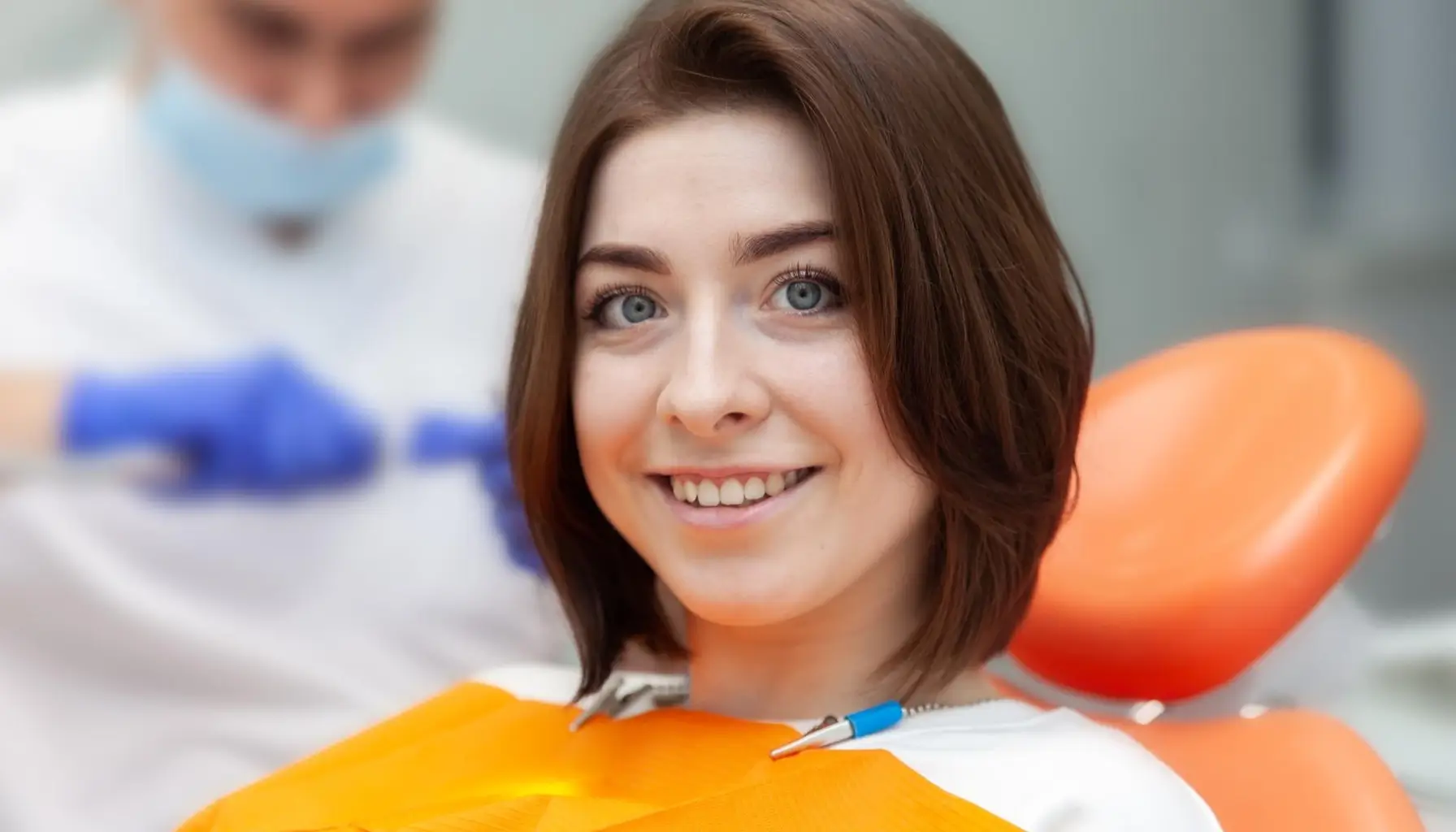 Femme souriante dans un cabinet dentaire équipé de technologies modernes pour un blanchiment dentaire professionnel réussi