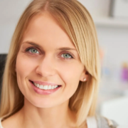 Femme souriante dans une clinique dentaire après un traitement réussi des caries.