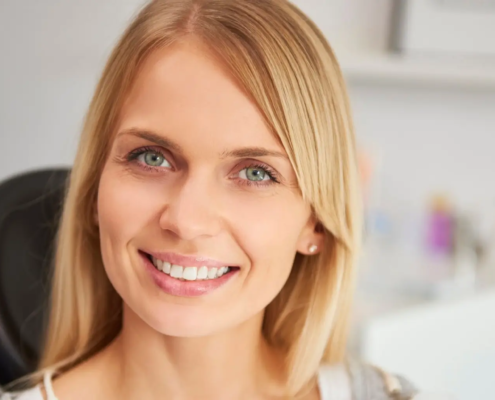 Femme souriante dans une clinique dentaire après un traitement réussi des caries.