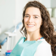 Jeune femme souriante chez le dentiste grâce à une alimentation anti-caries.