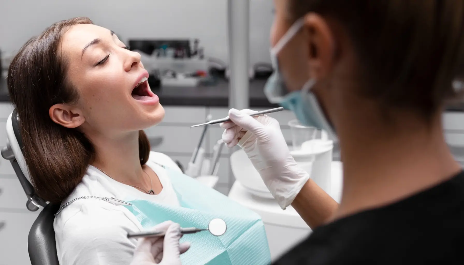 Belle patiente se faisant examiner les dents lors d'une visite de prévention des caries chez le dentiste.