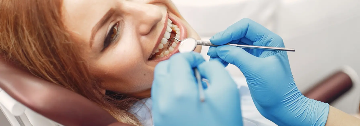 Jeune fille dans un cabinet dentaire, mettant en évidence l'éducation à l'hygiène buccale pour prévenir les caries chez les enfants et les adolescents.