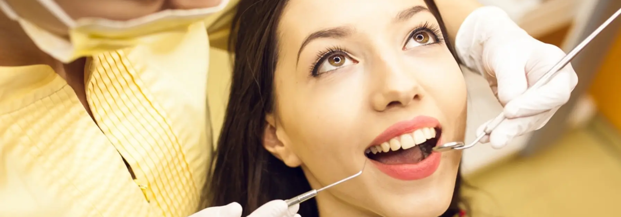 Femme souriante chez le dentiste pour un examen dentaire de routine