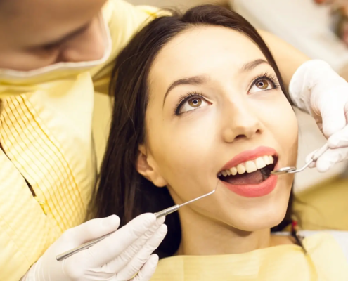 Femme souriante chez le dentiste pour un examen dentaire de routine