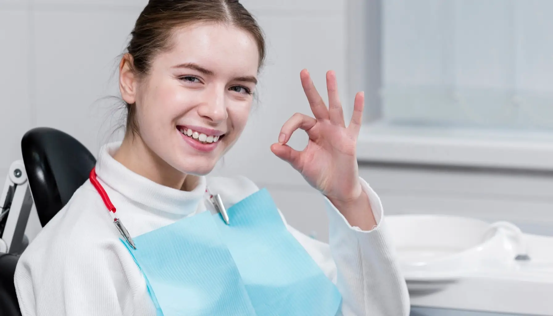 Femme souriante et satisfaite lors d'une visite de contrôle dentaire