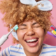 Jeune femme souriante avec des brosses à dents, dents saines grâce à une bonne hygiène bucco-dentaire et un dentifrice anti-caries.