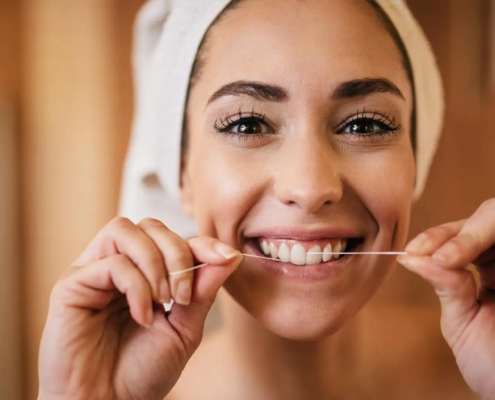 Femme se brossant les dents et utilisant du fil dentaire dans sa routine d'hygiène dentaire quotidienne.