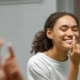 Femme joyeuse pratiquant son hygiène buccale avec un bain de bouche, illustrant les bienfaits d'une routine dentaire complète.