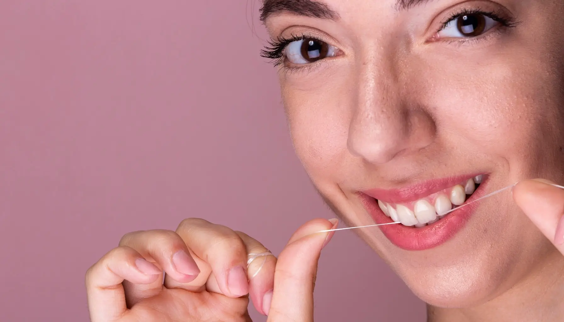 Adolescente prenant soin de son émail dentaire en utilisant du fil dentaire, complément essentiel à la fluoration pour prévenir les caries