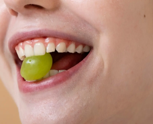 Femme souriante avec raisin, promouvoir une bonne hygiène bucco-dentaire et la prévention des caries dentaires.