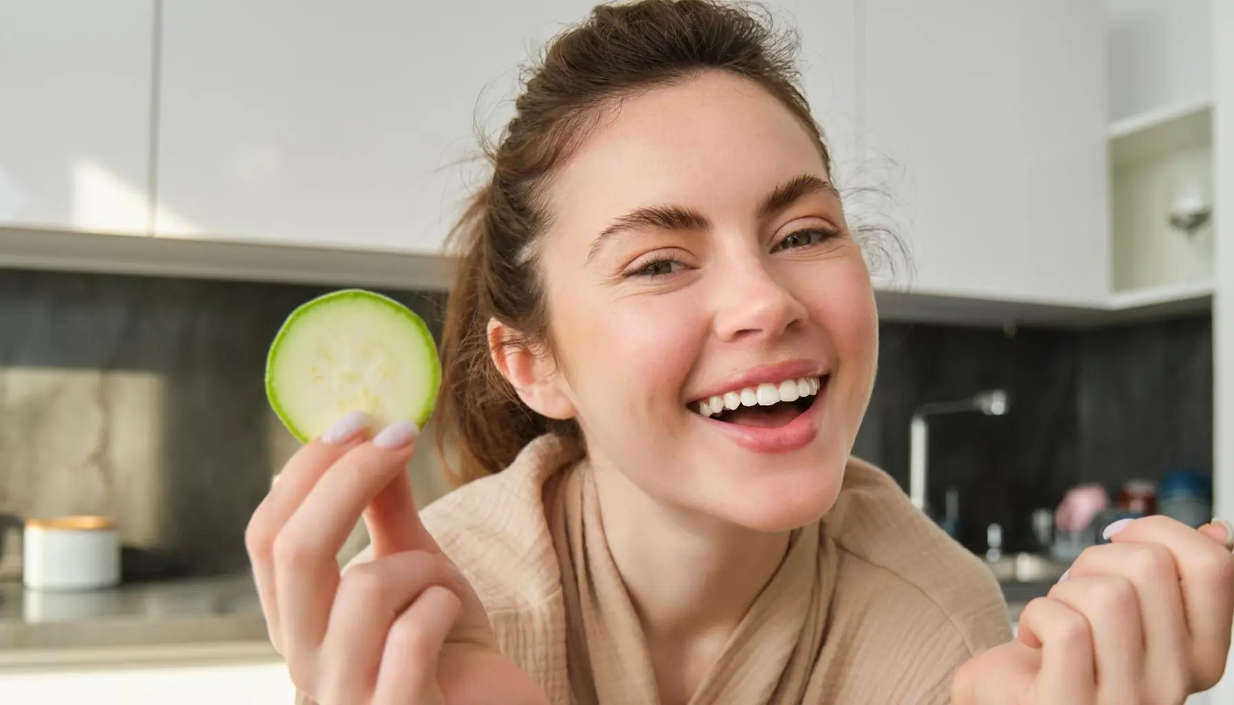 Femme souriante préparant des légumes, encourageant une alimentation saine pour la prévention des caries et une bonne hygiène bucco-dentaire.