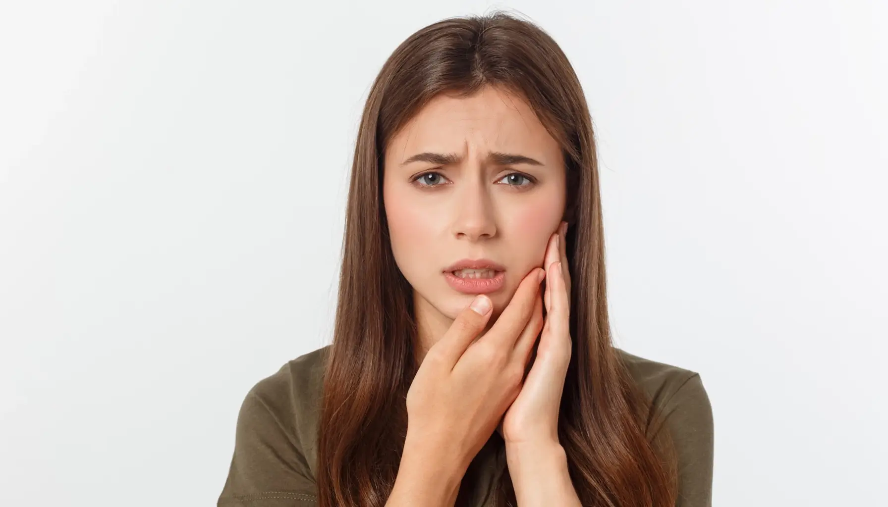 Adolescente souffrant de sensibilité dentaire aiguë, illustrant le besoin de traiter les causes de la sensibilité dentaire avec un dentifrice spécial adapté.