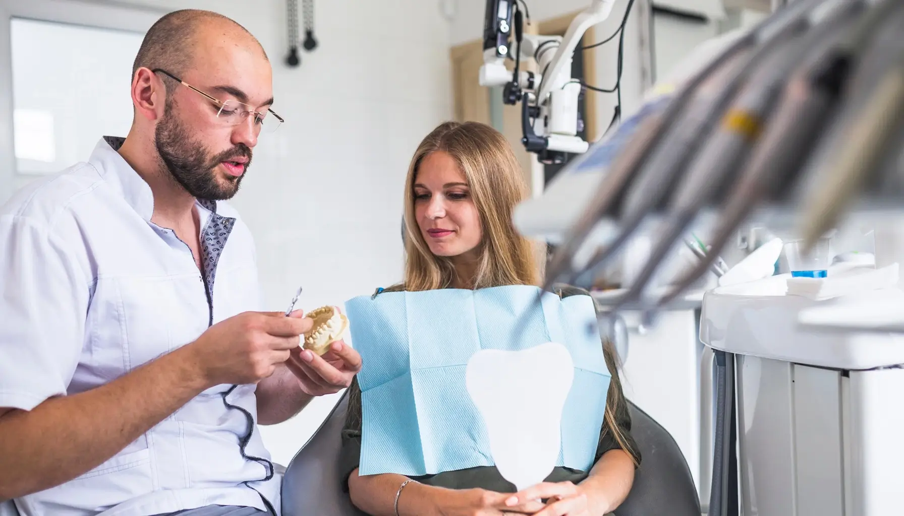 Dentiste examinant la santé buccale d'une patiente et discutant de l'importance de la salive.