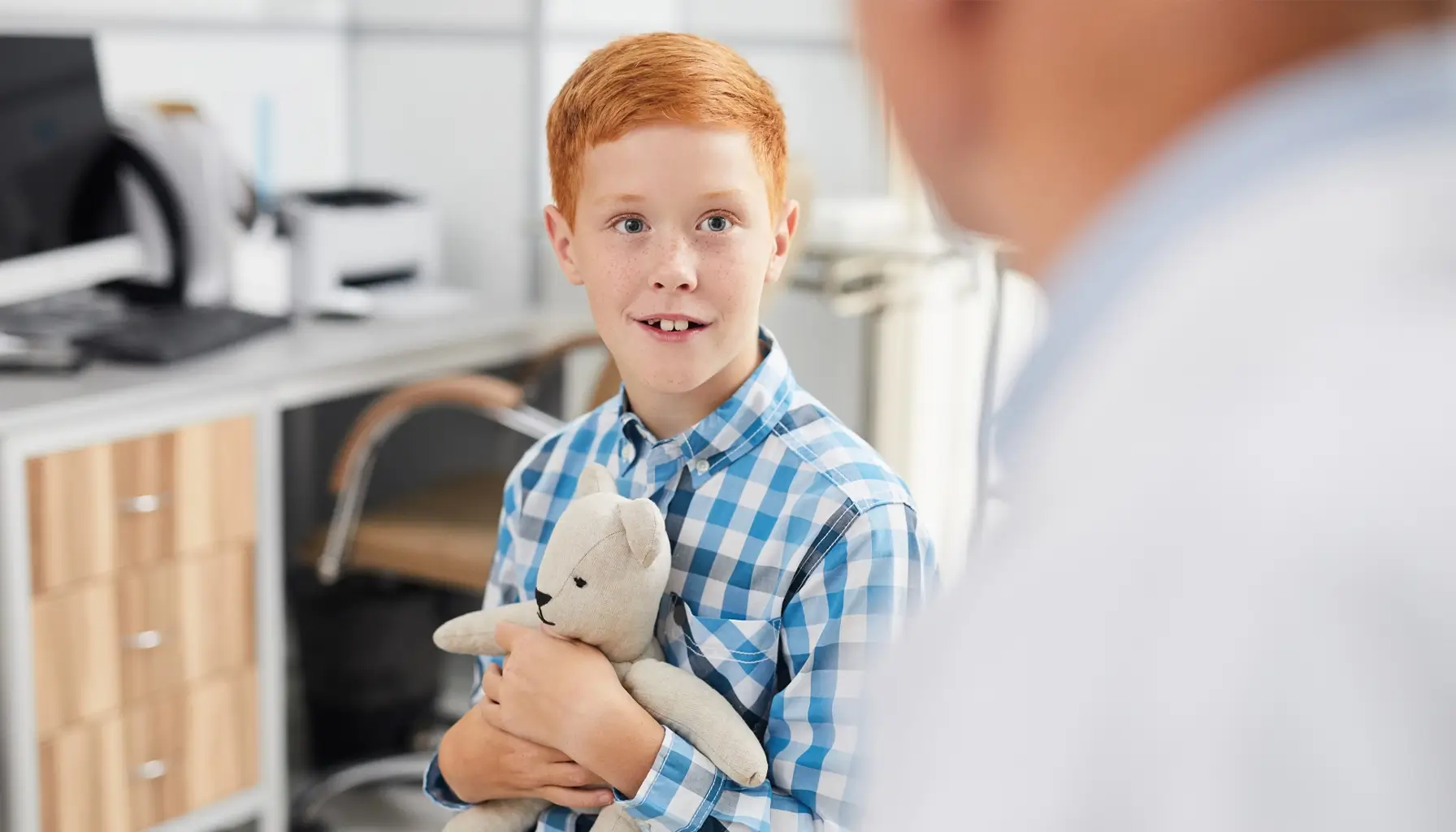 Garçon souriant chez le dentiste, illustrant l'importance des visites pour la santé dentaire des enfants.